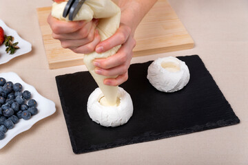 Pastry chef fills the cakes with cream. Chef's hands. Process, top view