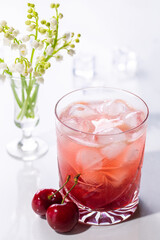 Beautiful red cherry cocktail in the summer sunshine