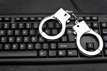Handcuffs on the keyboards. Internet scam concept. Internet fraud.