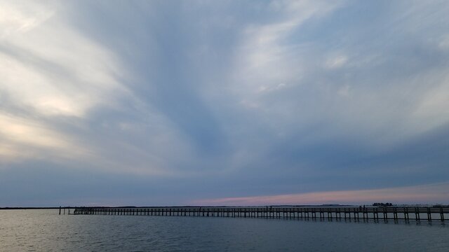 Dark Swirly Clouds With A Pink Horizon At Sunset