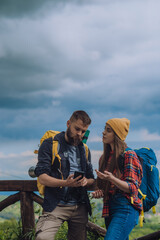 A couple of hikers using smartphone for orientation while spending time in nature