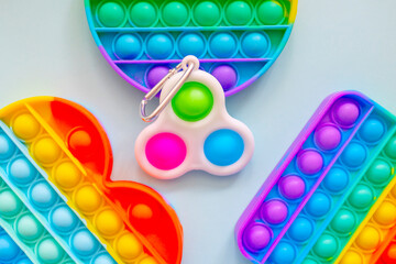 colorful trendy antistress sensory toy fidget push pop it and simple dimple on blue background