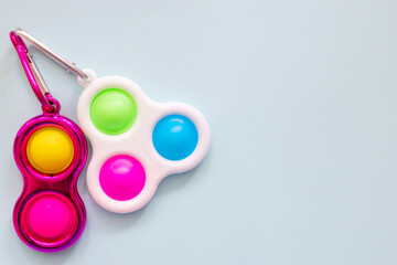 colorful antistress sensory toy fidget push simple dimple on blue background - obrazy, fototapety, plakaty