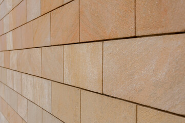 Modern sandstone facade cladding. Brown wall tiles imitating brickwork. Modern finishing material. Close-up of exterior facade decoration. Effective wall cladding system