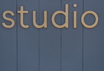 studio sign on a plank wall painted grey