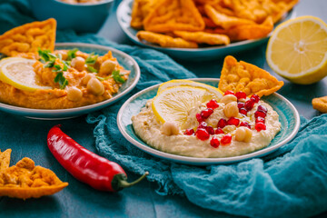 Homemade spicy humus with pomegranate seeds, chilli and chickpeas tortilla chips