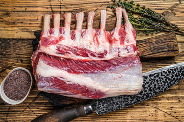 Raw Lamb ribs rack on a cutting board with knife. wooden background. Top view