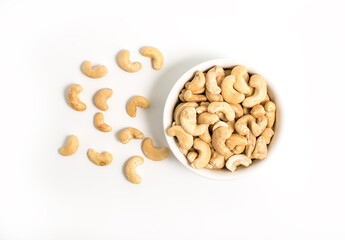 Raw Cashew nuts in a ceramic bowl isolated on a white background. Roasted cashew nuts - Top View