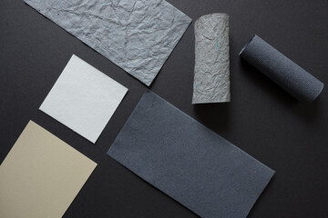 various pieces of rectangular construction paper arranged on grey mat board - photographed from above in a flat lay style