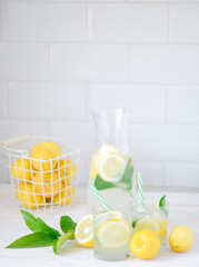 Fresh lemon lemonade with mint in bottle on kitchen table with ingredients. healthy nutrition diet concept. White background.