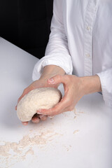Women's hands knead dough to make bread
