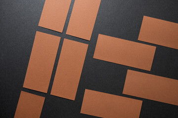 arranged brown construction paper rectangles on dark grey board - photographed from above in a flat lay style