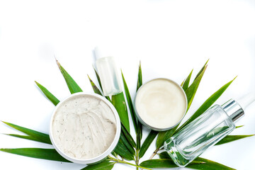 Fototapeta na wymiar face skin care products cream and scrub on white background with green leaves