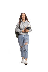 Full length portrait of a female student carrying books and walking towards camera