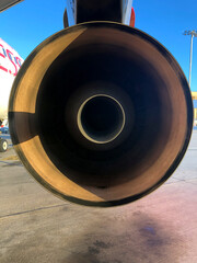 Rear of jet engine of Airbus A-320 commercial airplane with exhaust pipe in the foreground