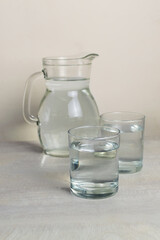 Two glasses and a glass jug of clean water are on the table.