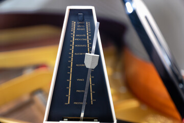 Metronome with pendulum to keep rhythm and tempo for piano, classical music, musicians - close-up...