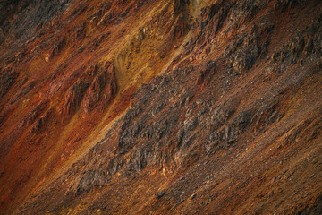 Scenic nature background of multicolor mountain. Colorful nature backdrop of motley rocks. Multicolor great rocks of vivid colors. Beautiful red orange rufous golden rocks. Closeup of motley mountain.