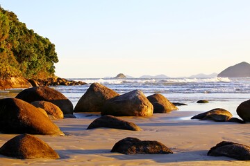 Blue sea with small white waves. In the background, the sky was clear. In front of small stones in the water. Restful marine scenery.