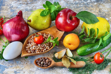 Organic food for diet. Healthy food: buckwheat porridge, chicken egg, black pepper, garlic, apple, pear, apricot, lemon, red onion, cherry tomato, cucumber, dill, cilantro, green mint and bay leaf