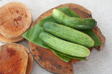 Fresh cucumbers on an old wooden cutting board