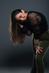 Portrait of beautiful model in black dress, hat and sunglasses on gray background