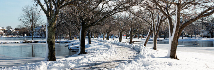 Walking path shoveled after snow storm between two lakes at Argyle Park in Babylon Village