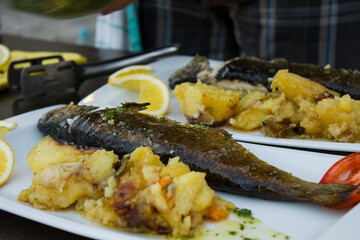 Fish and potatoes and vegetables on dish
