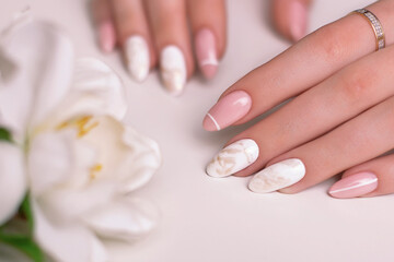 Beautiful female hands with luxury manicure nails, pink and white gel polish