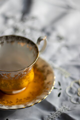 A close up of a yellow and gold coffee/tea cup 