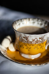 A close up of a yellow and gold coffee/tea cup 