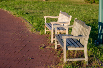 夕日が当たる夏の公園のベンチ
