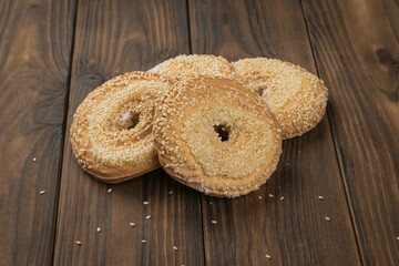 Four sesame cookies on a wooden table.