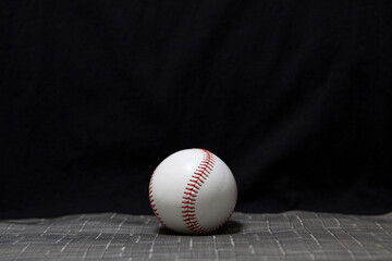 A baseball with a black background