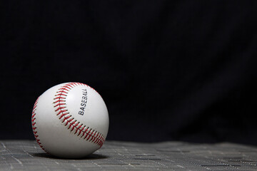 A baseball with a black background