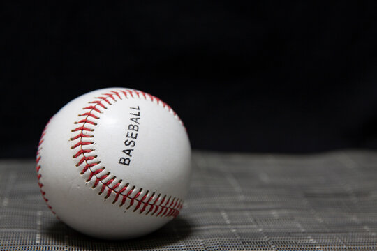 A baseball with a black background