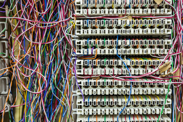 Inside a PABX telephone booth that has a number of connecting cables in many colors in the analog...