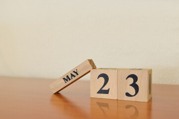 May 23, Date design with calendar cube on wooden table and white background.