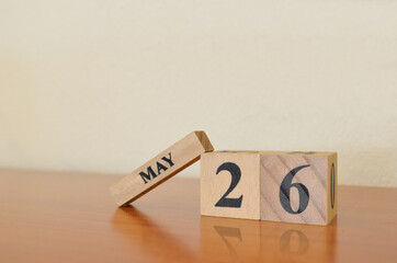 May 26, Date design with calendar cube on wooden table and white background.