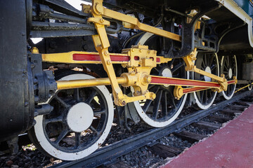Close-up of the wheels of a steam engine with an interlocking mechanism.