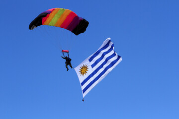 Militar desciende en paracaídas con la bandera de Uruguay 