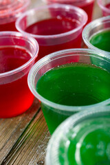 A closeup view of several plastic cups filled with gelatin.