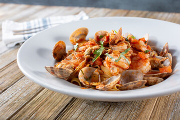 A view of a plate of fruite de mar. This is a shellfish and pasta dish featuring fettuccine, clam, and shrimp.