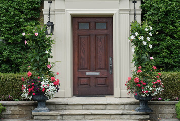 Fototapeta na wymiar Elegant dark wood grain front door with vines and flower pots