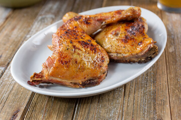 A view of a plate of baked chicken quarters.