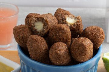 Kibbeh stuffed with cheese in a blue bowl.