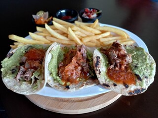Tacos de longaniza, acompañados con guacamol, pico de gallo, papas fritas y salsa picante....
