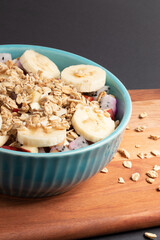 Bowl of healthy ripe salad fruits with granola.
