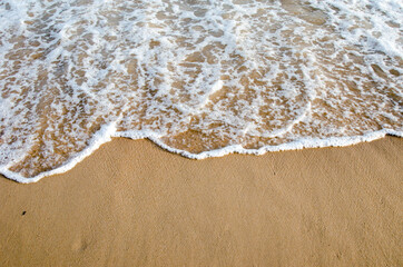 Waves hitting sand shore on a late evening. Photo taken in Asia, Thailand