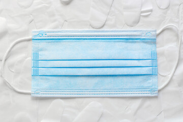 Surgical mask with medical grade disposable gloves above white bacground. Infection prevention...